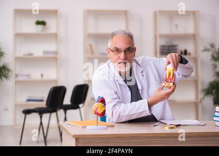 Alte Zahnarztlehrerin sitzt im Klassenzimmer Stockfoto
