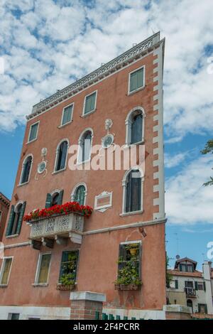 Fassade eines Hauses mit einem blühenden Balkon in Venedig Stockfoto