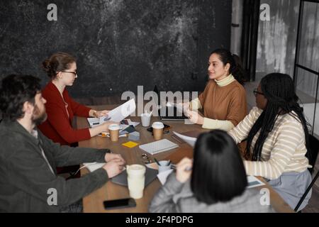 Seitenansicht Porträt einer jungen Frau aus dem Nahen Osten im Gespräch mit Diverse Gruppe von Kollegen Stockfoto