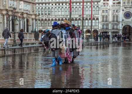 Hochwasser in Venedig zieht der Verkäufer seinen Wagen mit Waren Stockfoto