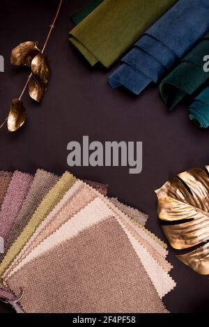 Light Set Sail Champagner und graue Farben gunny Textilmuster mit Gold Monstera Blätter auf einem schwarzen Tisch verziert. Stockfoto