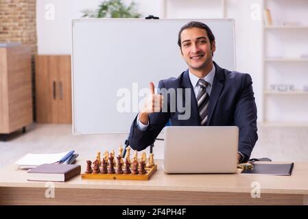 Junge Geschäftsmann Mitarbeiter spielen Schach am Arbeitsplatz Stockfoto