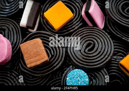 Schwarze Lakritz-Strudel, kauen Süßigkeiten und köstliche Dessert-Konzept mit Makro-Nahaufnahme auf Lakritz Räder und andere sortierte Lakritze mit einer Mischung aus col Stockfoto