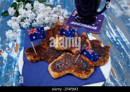 Ein Toastteller mit Vegemite, dem kultigen australischen Bohnenkraut, das in die Form Australiens geschnitten wurde, als besonderes Frühstück für den Australia Day. Stockfoto