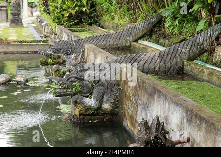 Eine steinerne Tierstatue mit einem Brunnen in der Nähe eines künstlichen Beckens bei Tirta Gangga, Karangasem Region der Bali Insel, Indonesien Stockfoto