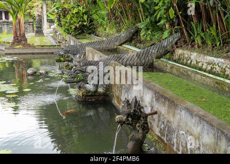 Eine steinerne Tierstatue mit einem Brunnen in der Nähe eines künstlichen Beckens bei Tirta Gangga, Karangasem Region der Bali Insel, Indonesien Stockfoto