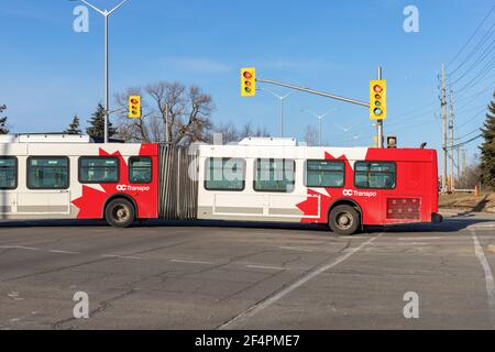 Ottawa, Kanada - 19. März 2021: Öffentlicher Bus, der an einer Kreuzung in Kanada vorbeifährt Stockfoto