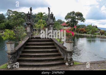 Eine künstliche Brücke mit vier Statuen von Drachen mit verdrehten Schwänzen, Tirta Gangga Park, Karangasem Region der Bali Insel, Indonesien Stockfoto