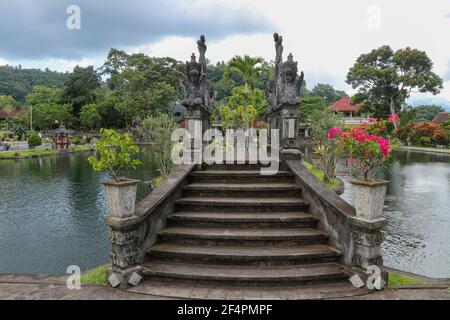 Eine künstliche Brücke mit vier Statuen von Drachen mit verdrehten Schwänzen, Tirta Gangga Park, Karangasem Region der Bali Insel, Indonesien Stockfoto