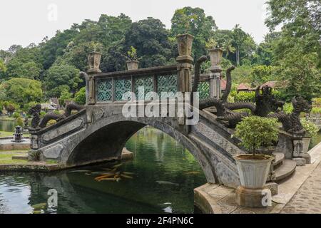 Eine künstliche Brücke mit vier Statuen von Drachen mit verdrehten Schwänzen, Tirta Gangga Park, Karangasem Region der Bali Insel, Indonesien Stockfoto