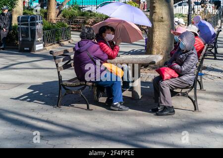 New York, NY - 22. März 2021: Asiatisch-amerikanische New Yorker verbringen einen ruhigen, warmen Frühlingstag im Columbus Park und spielen Karten, chinesisches Schach oder genießen einfach nur den Tag Stockfoto