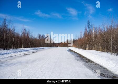 Luftaufnahme des Flusses und Taiga Wälder und Straße im Winter - Frühling . Abstrakte Landschaft der nördlichen Natur mit Drohne. Stockfoto