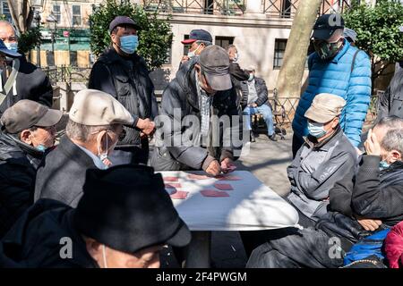 Asiatisch-amerikanische New Yorker verbringen einen ruhigen, warmen Frühlingstag im Columbus Park und spielen Karten, chinesisches Schach oder genießen einfach den Tag. Park sieht am nächsten Tag nach einer großen Kundgebung gegen asiatisch-amerikanische Hassverbrechen völlig friedlich und anders aus. Die einzige Erinnerung sind Blumen und ein Plakat an der Skulptur von Dr. Sun Yat-sen. Es gibt Frauen und Männer, die Karten auf separaten Tischen spielen, alle tragen Gesichtsmasken, aber die Mehrheit der Frauen tragen auch Schutzhandschuhe. (Foto von Lev Radin/Pacific Press) Stockfoto