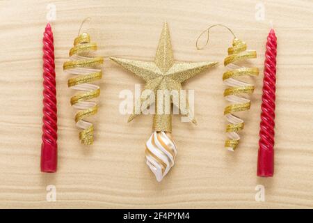 Weihnachtsstern und Dekorationen auf Sand. Foto kann als ganzer Hintergrund verwendet werden. Stockfoto