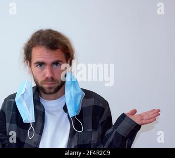 Spanischer junger bärtiger Mann, der Schutzgesichtsmasken falsch trägt Stockfoto