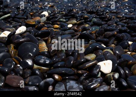 Nahaufnahme von glatten schwarzen Steinen auf koh hin ngam, Provinz Satun, Thailand. Stockfoto