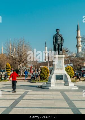 Edirne, Türkei - 26. Februar 2021 - Vertikale Ansicht der Menschen auf einem Platz mit Atatürk-Statue, Selimiye-Moschee und der Alten Moschee (Eski Camii) in Edirne, Stockfoto