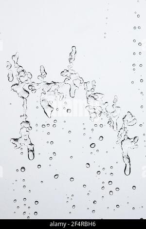 Wassertropfen Hintergrund. Makroansicht von eisigen Regentropfen auf dem Fenster, die abstrakte geometrische grafische Formen erzeugen. Nahaufnahme Stockfoto
