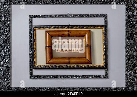 Komposition mit Rahmen verschiedener Größen und Materialien mit dem Wort 'cornici' oben, das im Italienischen Frames bedeutet Stockfoto