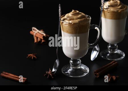 Dalgona cremiger Kaffee in zwei Gläsern auf schwarzem Hintergrund mit Schlagschaum. Koreanischer Kaffeetrend, Nahaufnahme, horizontales Format Stockfoto