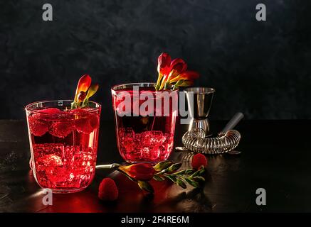 Himbeer-Alkoholcocktail mit Likör, Wodka, Eis und Sodawasser auf dunklem Hintergrund. Berry Mojito. Stockfoto