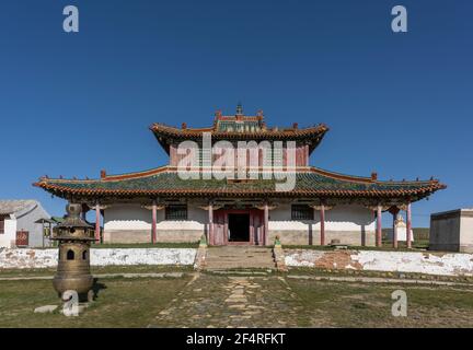 Shankh, Mongolei - 29. August 2019: Tempel des Shankh-Klosters mit Mönch und Hund im Sommer vor dem Tempel mit blauem Himmel. Stockfoto