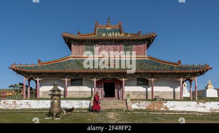 Shankh, Mongolei - 29. August 2019: Tempel des Shankh-Klosters mit Mönch und Hund im Sommer vor dem Tempel mit blauem Himmel. Stockfoto