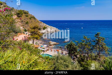 Taormina, Italien - 25. Juli 2020 - Schwimmer und Menschen sonnen sich am Strand Isola Bella auf Sizilien Stockfoto