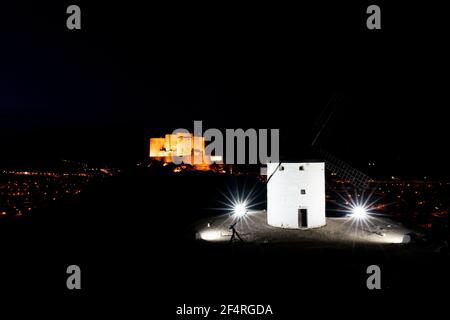 Ein Blick auf die Windmühle und das Schloss von Consuegra in La Mancha in Zentralspanien bei Nacht Stockfoto