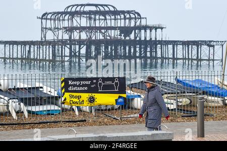 Brighton UK 23rd March 2021 - Spaziergänger früh entlang Brighton Küste am ersten Jahrestag der Coronavirus COVID-19 Sperre in Großbritannien, wie das Land wird einen nationalen Tag der Reflexion mit einer Minute Stille am Mittag und Kerzen angezündet heute Abend an der Tür : Kredit Simon Dack / Alamy Live Nachrichten Stockfoto