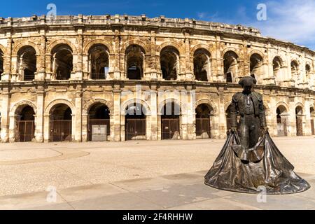 Nimes, Frankreich - 15. März 2021: Blick auf das römische Amphitheater in Nimes mit der Statue des Stierkämpfer Nimeno Stockfoto