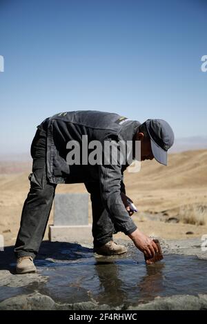 (210323) -- SUNAN, 23. März 2021 (Xinhua) -- Du Chengfeng klärt die Oberfläche eines Felsbildes auf dem Leishan Berg im Yugu Autonomen Landkreis Sunan, nordwestlich der chinesischen Provinz Gansu, 22. März 2021. Du Chengfeng, 45, wurde aus der Familie eines Hirten geboren. Aus Interesse und Leidenschaft hat er in den letzten 20 Jahren über 12.000 Felsmalereien über die Qilianischen Berge gesammelt. Er verbringt oft über 100 Tage im Jahr auf der Suche nach verschiedenen Felsbildern im tiefen Berg. Du begann 2012 im Kulturbereich zu arbeiten. Auf seinen Vorschlag, die lokalen Behörden auf Verwaltung o Stockfoto