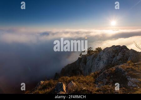 Landschaft mit Sonne und Nebel über Wolken Stockfoto