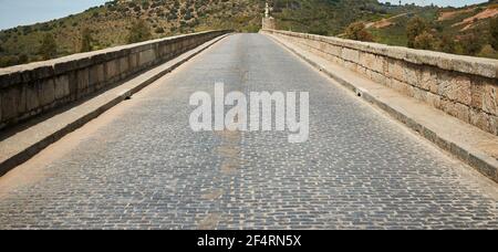 Gepflasterte Straße über Steinbrücke hispanischen römischen Ursprungs Stockfoto