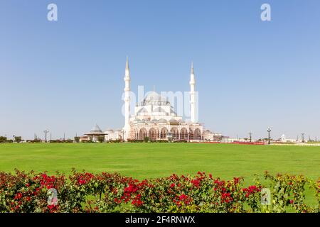 Neue Sharjah Moschee (Sharjah Masjid), die größte Moschee im Emirat Sharjah, den Vereinigten Arabischen Emiraten, weiße Sandsteinfassade mit Kuppeln. Stockfoto