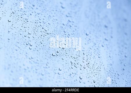 Wassertropfen sind auf einem Glas unter blauem Himmel, Hintergrund Foto Textur Stockfoto