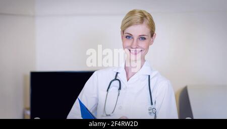 Porträt einer kaukasischen Ärztin, die im Laborkittel lächelt Krankenhaus Stockfoto
