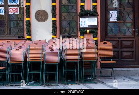 München, Deutschland. März 2021, 23rd. Tische und Stühle stehen vor einem geschlossenen Restaurant im Stadtzentrum. Die seit Monaten andauende Sperrung in Deutschland wird aufgrund steigender Corona-Infektionszahlen bis zum 18. April verlängert. Quelle: Sven Hoppe/dpa/Alamy Live News Stockfoto