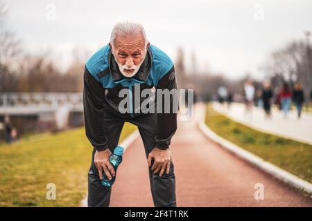 Aktiver älterer Mann ist nach dem Training erschöpft. Gesunder Lebensstil im Ruhestand. Stockfoto