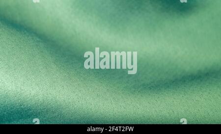 Schöne gewellte Seidenstoff in aqua Farbe. Glatte elegante Luxus Stoff Textur. Abstraktes grünes Hintergrunddesign. Kopierbereich, selektiver Fokus Stockfoto