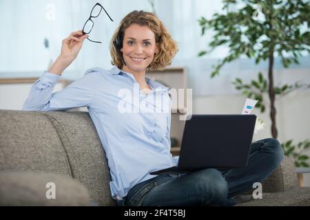 Glückliche freiberufliche Frau nehmen Brille Stockfoto