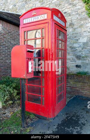 Ein traditioneller roter Royal Mail Briefkasten neben rotem Telefonkiosk im Dorf Towton, North Yorkshire Stockfoto