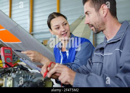 Männliche und weibliche Mechanik mit Multimeter in der Werkstatt Stockfoto