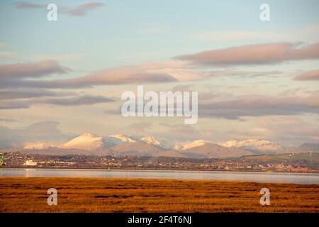 Blick über die Lakeland Mountains und Barrow in Furness von Walney, Cumbria, Großbritannien, bei Sonnenuntergang. Stockfoto