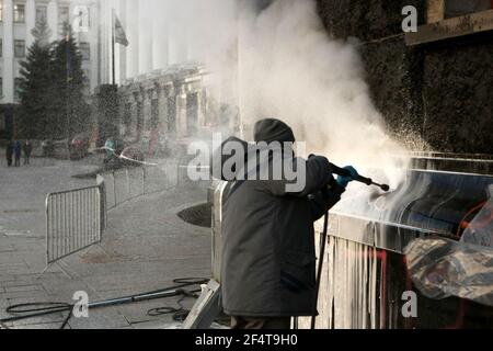 KIEW, UKRAINE - 23. MÄRZ 2021 - EIN Arbeiter wäscht weg Graffiti von der Wand des Büros des Präsidenten auf 11 Bankova Straße nach dem 20. März PR Stockfoto