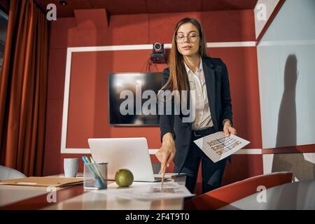 Fokussierte Zeichnerin, die den Grundriss betrachtet Stockfoto