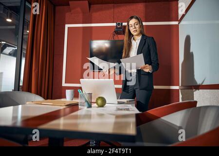 Die junge Frau in der Brille konzentrierte sich auf ihre technischen Zeichnungen Stockfoto
