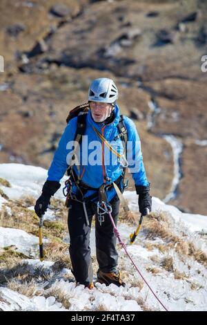 Eiskletterer Klettern Low Water Beck gefroren im Winter auf den Hängen des Coniston Old man, Lake District, Großbritannien. Stockfoto