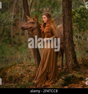 Rotschopf Mädchen mit Hirsch in einem langen Kleid Stockfoto