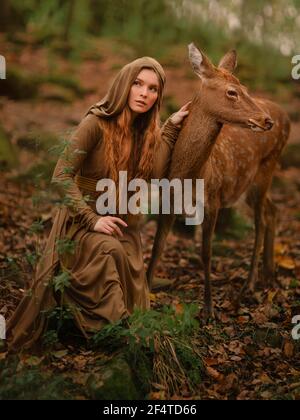 Rotschopf Mädchen mit Hirsch in einem langen Kleid Stockfoto